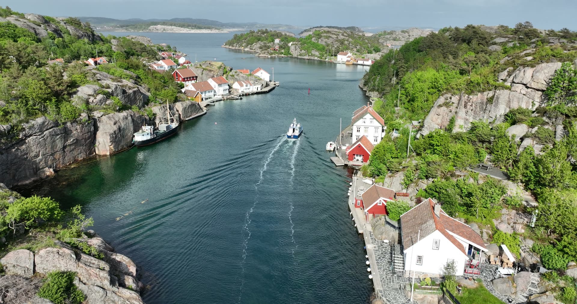 Fishing boat navigating narrow rocky channel, Ny-Hellesund, Norway