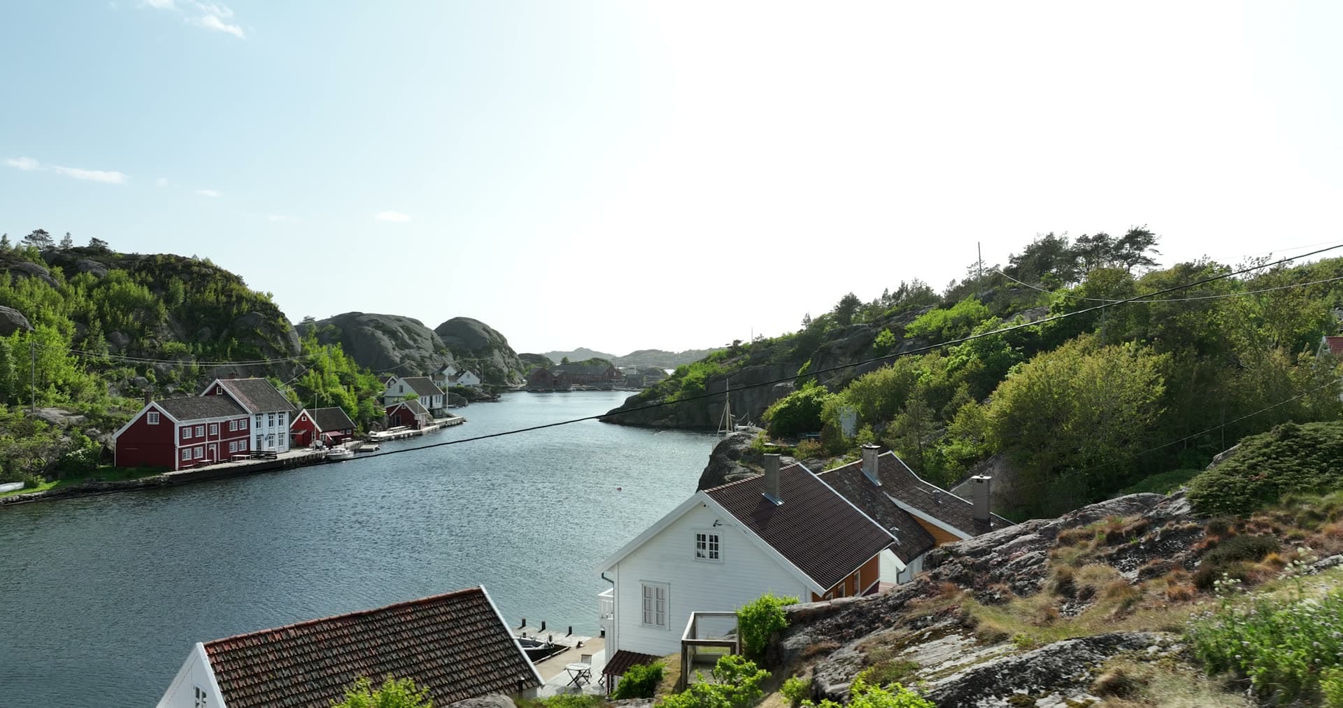 Sheltered waterway framed by dense forest and granite, Ny-Hellesund, Norway