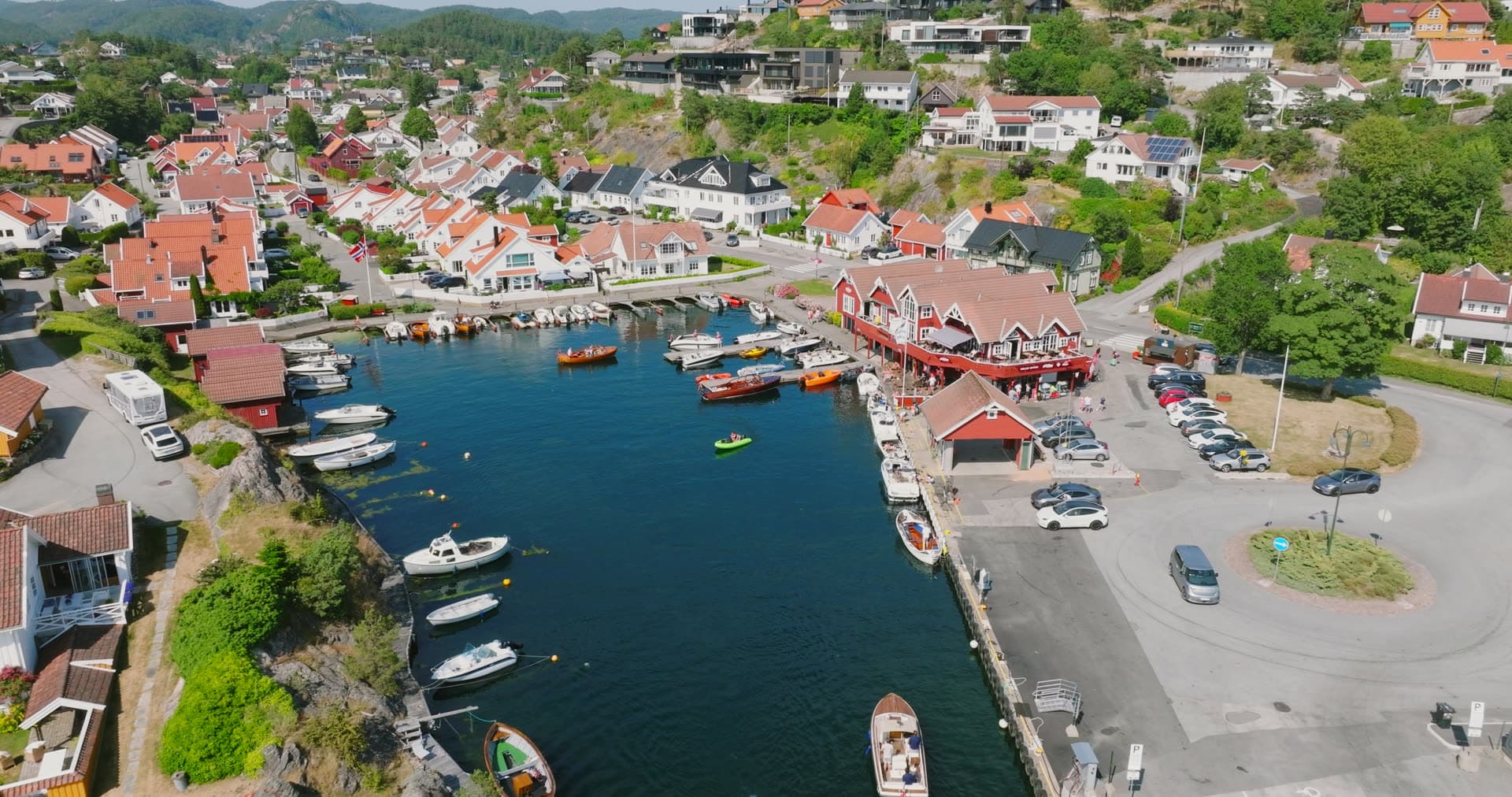 Narrow harbor basin surrounded by hillside homes, Høllen, Norway