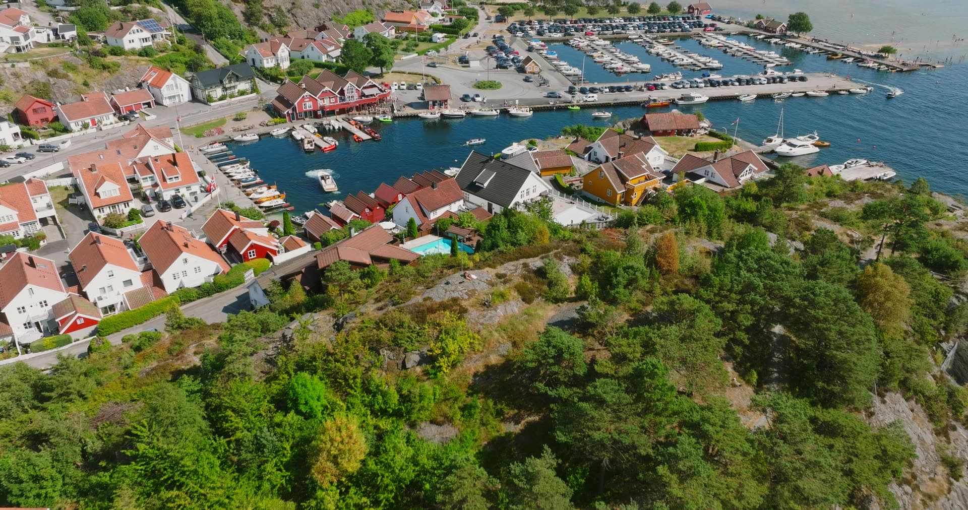 Forested headland separating residential waterfront from marina, Høllen, Norway