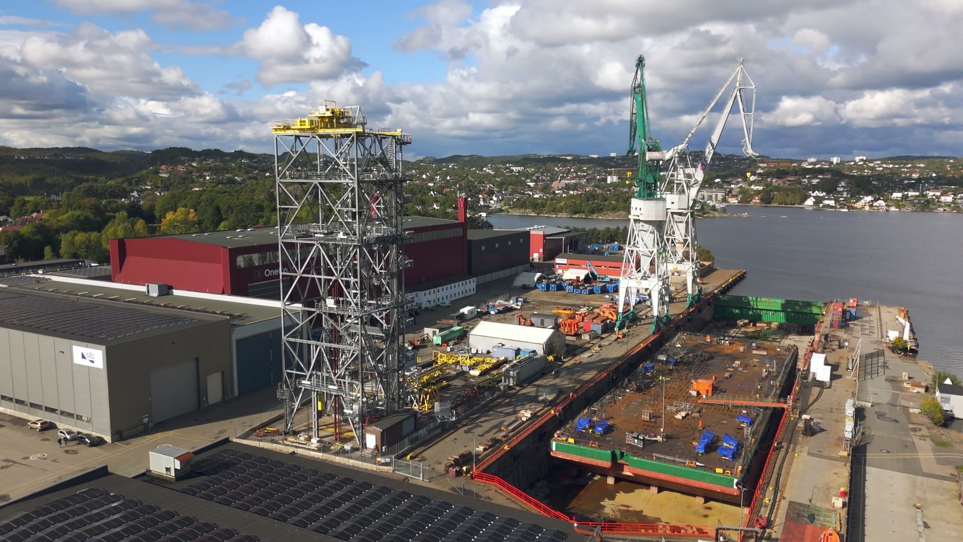 Shipyard with docked vessel and tall loading cranes, Kristiansand, Norway