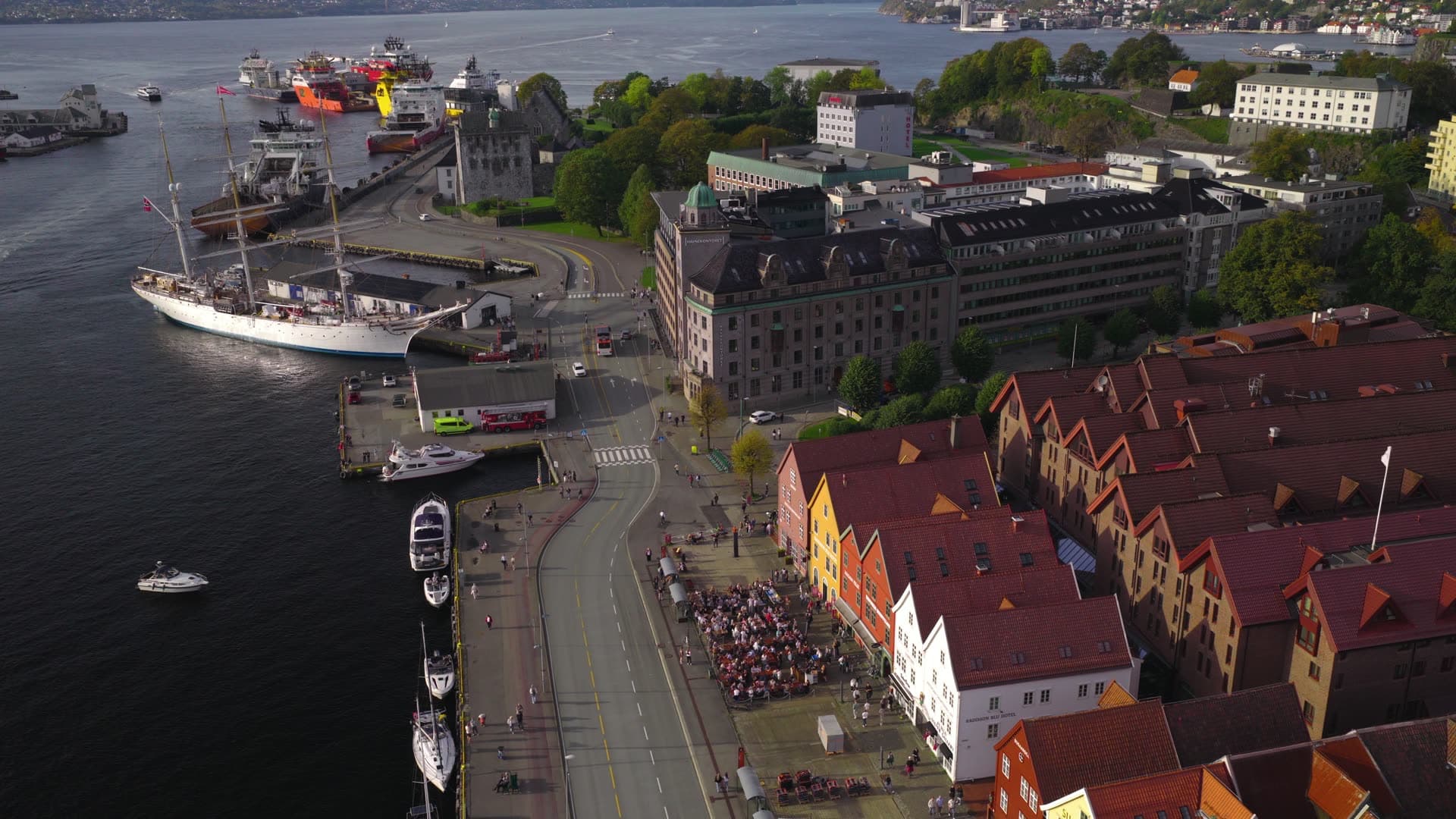 Crowds gathering at historic waterfront plaza, Bryggen, Bergen, Norway