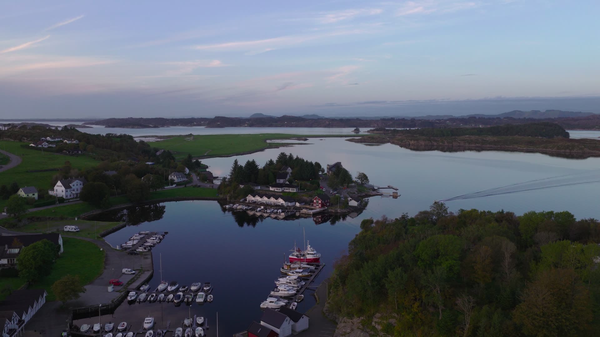 Small marina with moored boats and waterfront village, Herdla