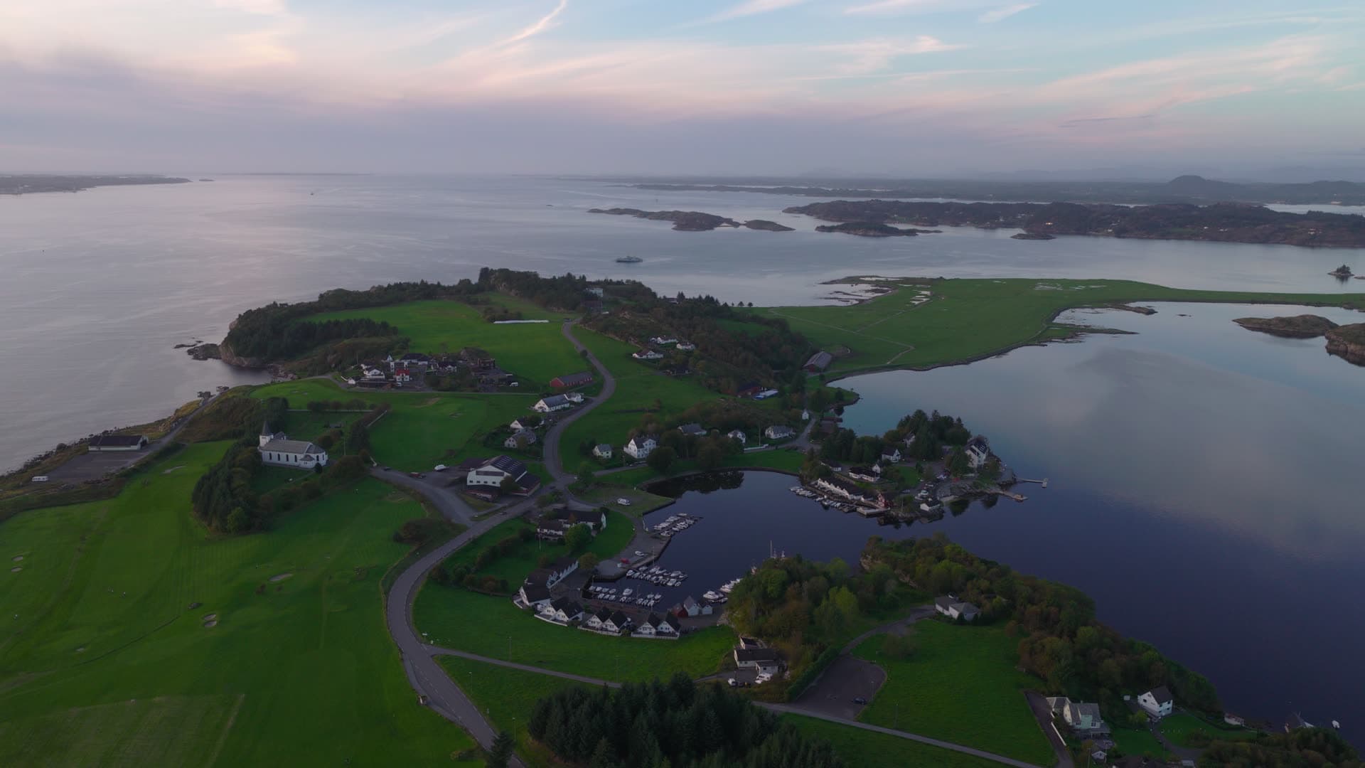 Waterfront coastal community with peninsula and bay, Herdla