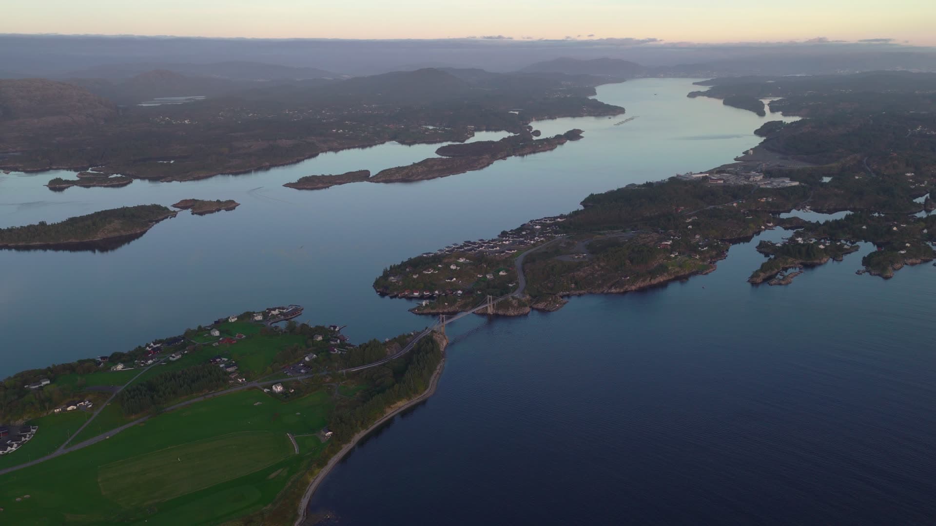 Lake with forested islands and scattered homes, Herdla