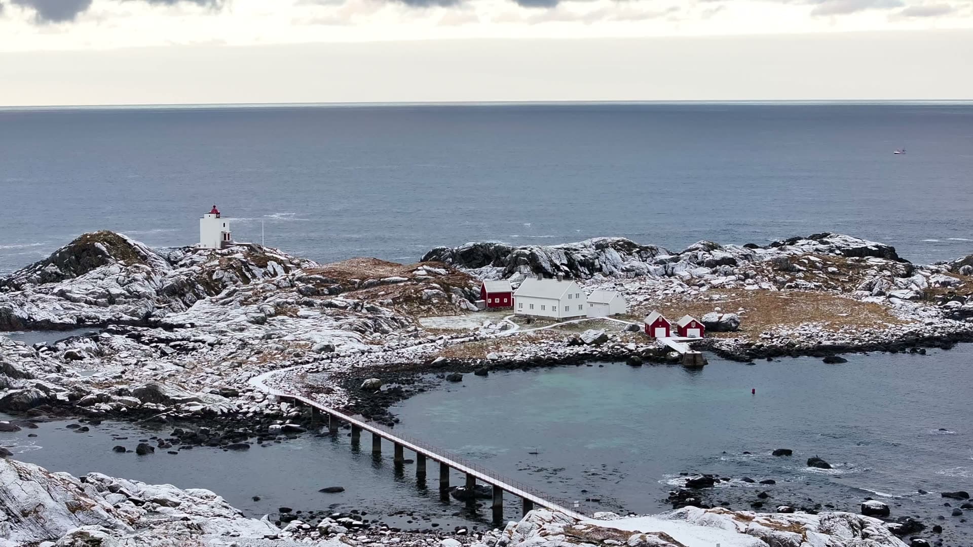 Ulla lighthouse and footbridge on a snowy coastal island