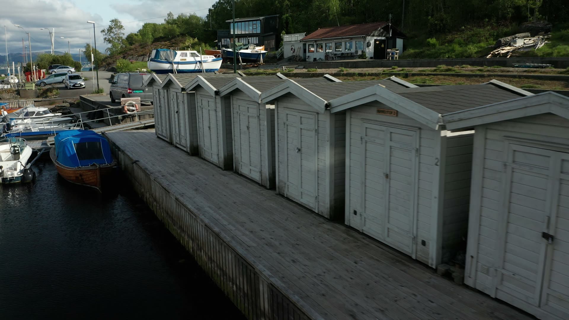 Riverside boathouses and moored boats, Lervig