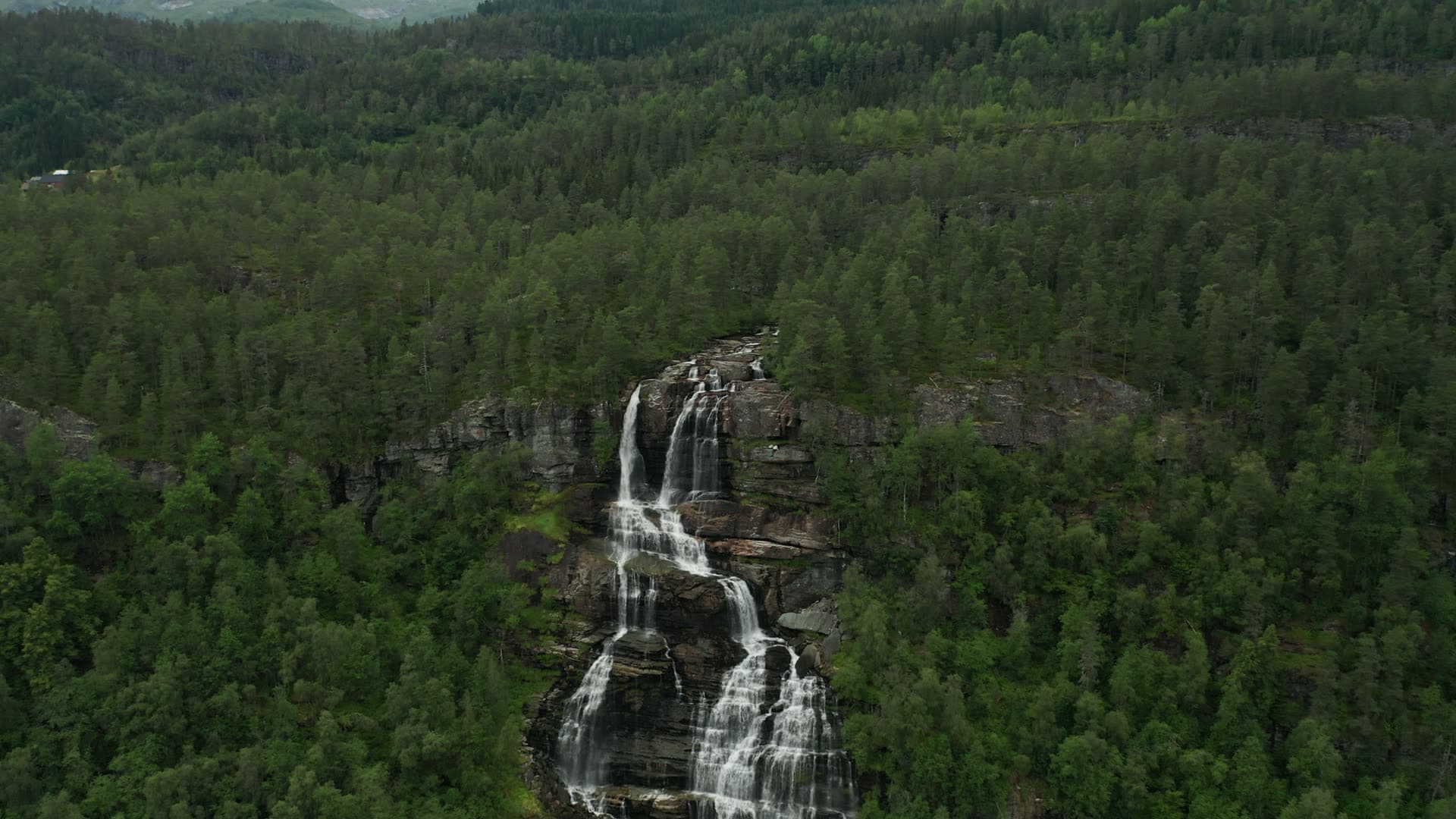 Multi-tiered waterfall in evergreen forest, Trollafossen