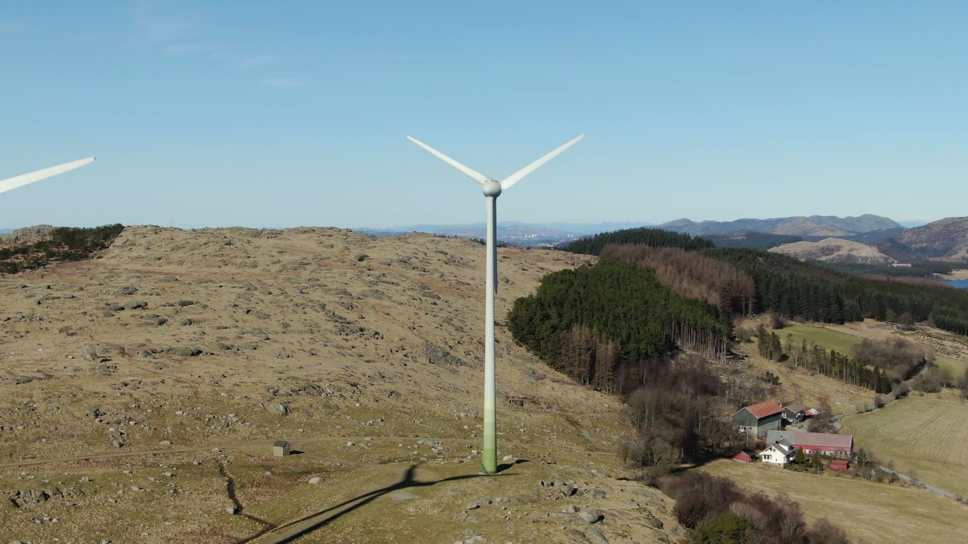 Wind turbine rotating on rural hillside, Rogaland