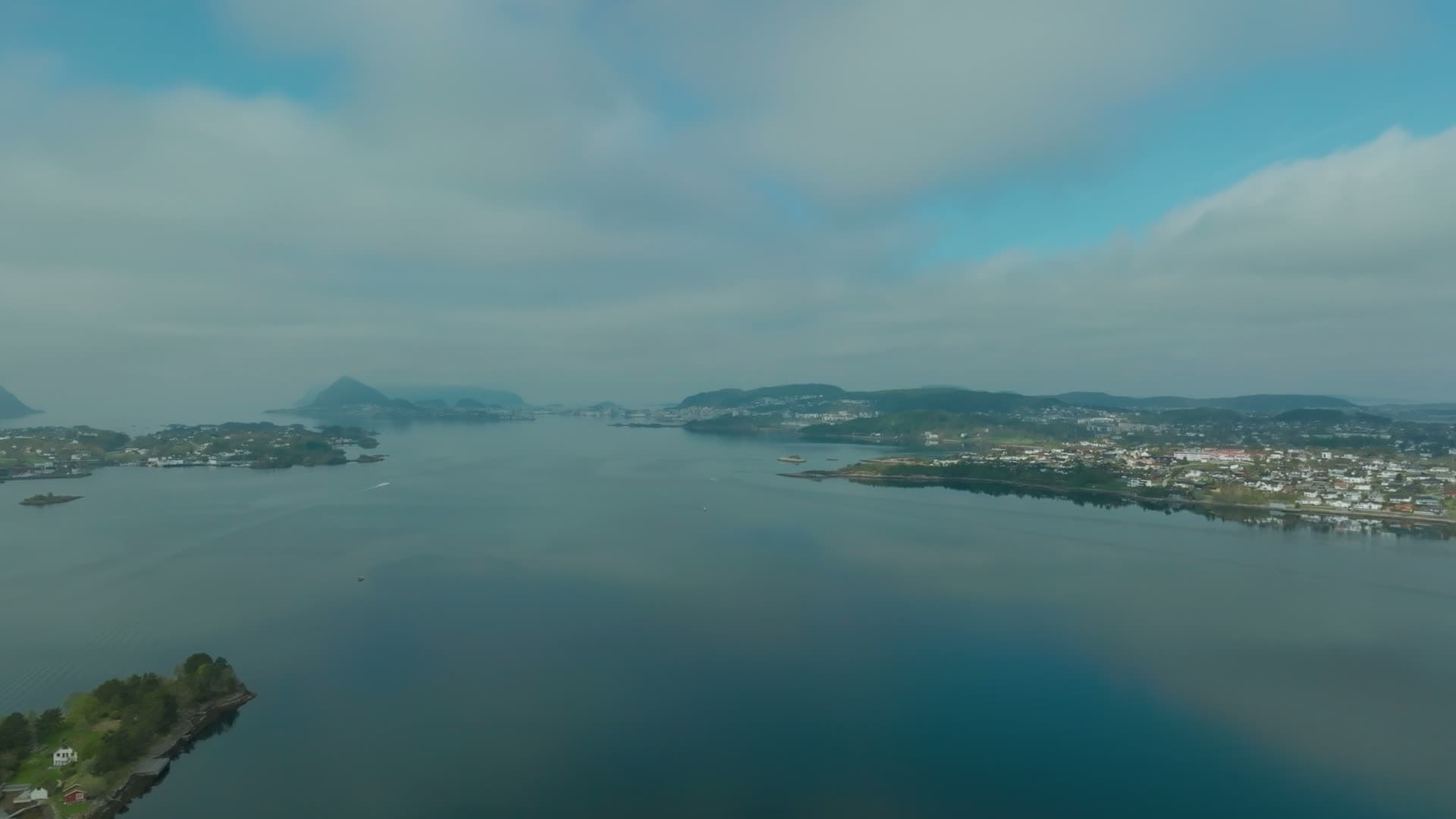 Wooded islet and flat calm strait to town, Ålesund, Norway