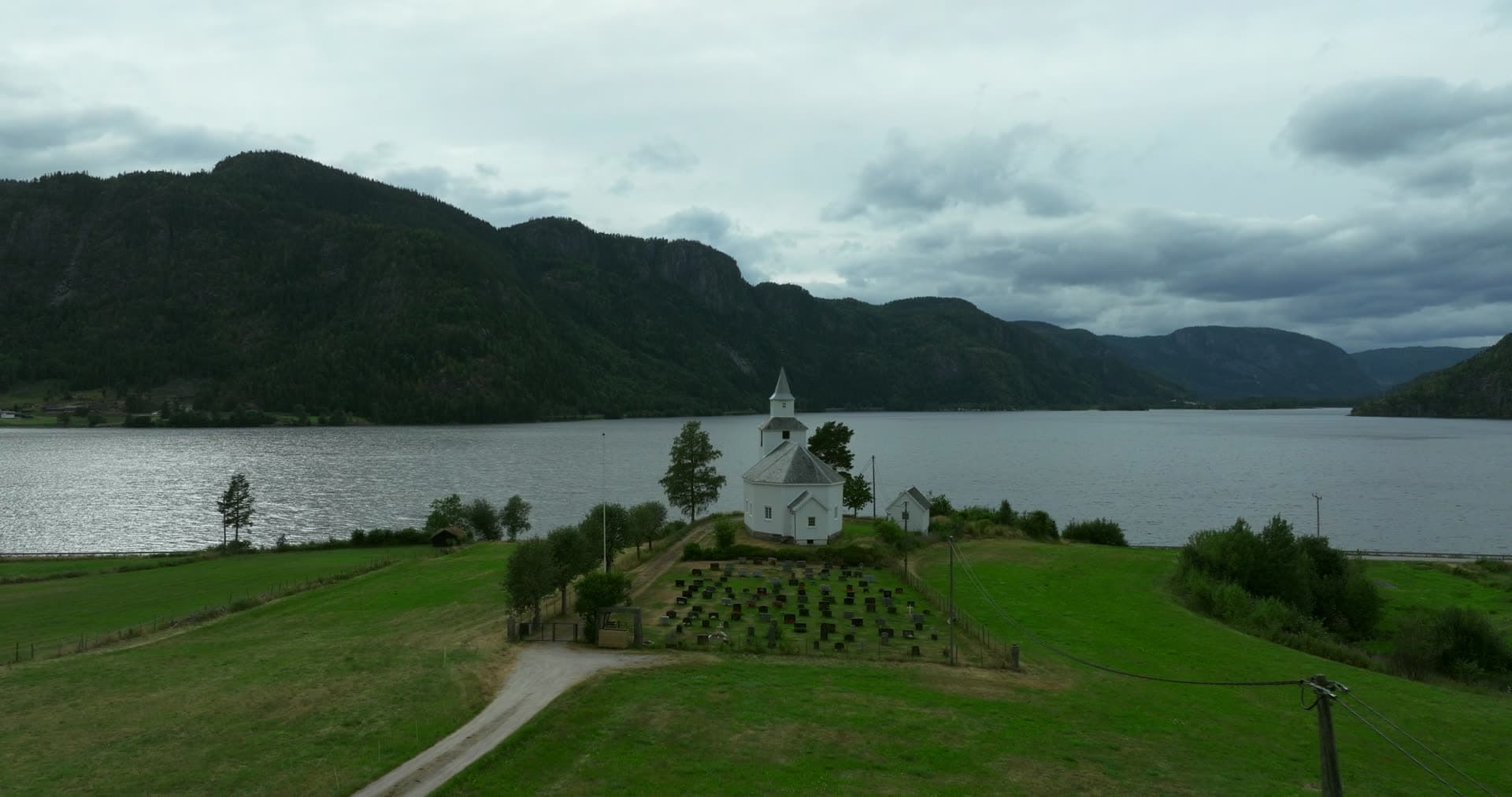 White church surrounded by young planted trees, Åraksbø, Bygland, Norway