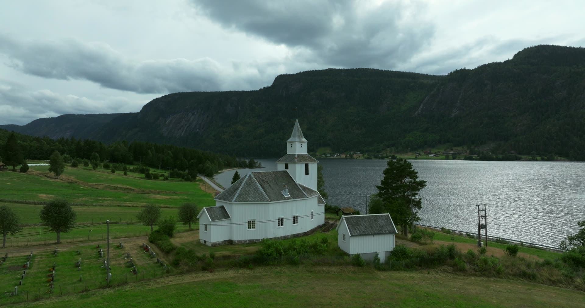 White church with newly planted saplings surrounding grounds, Åraksbø, Bygland, Norway