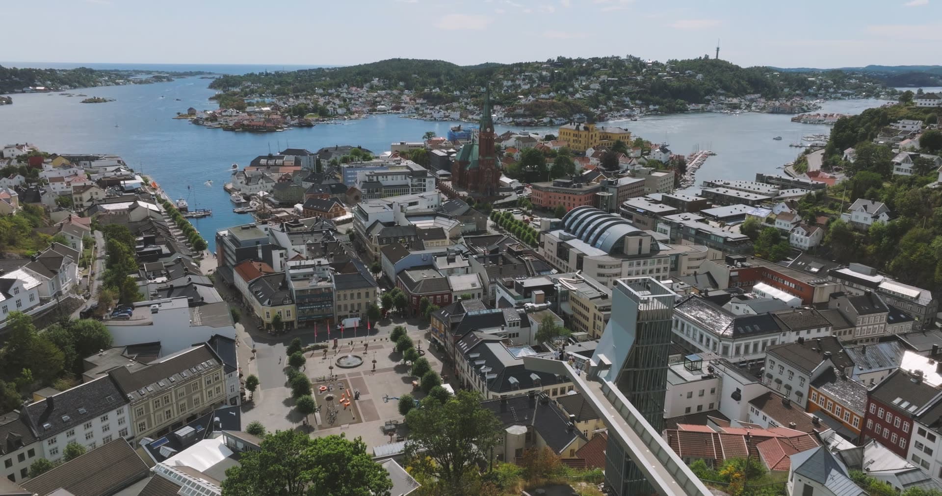 Curved modern building beside historic town square, Arendal, Norway