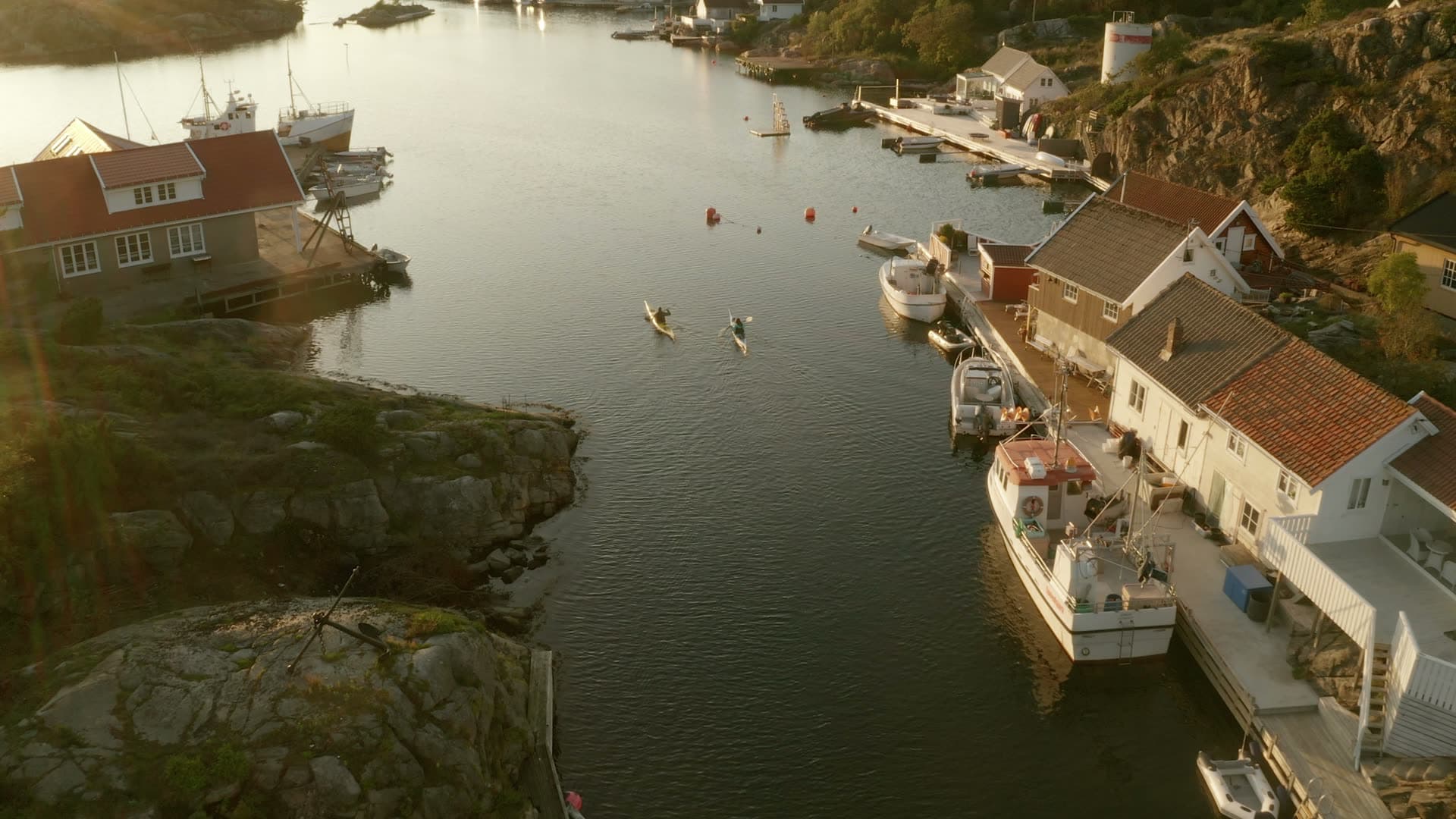 Two kayakers paddling through harbour inlet, Flekkerøy, Norway