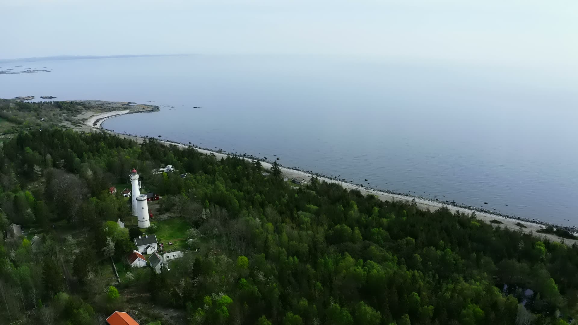 Lighthouse tower rising through dense coniferous forest, Jomfruland, Norway
