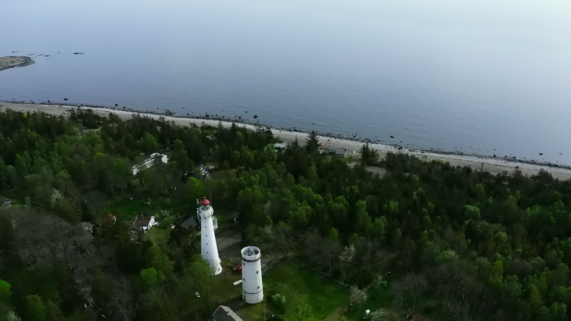 Two lighthouse towers surrounded by coniferous forest, Jomfruland, Norway