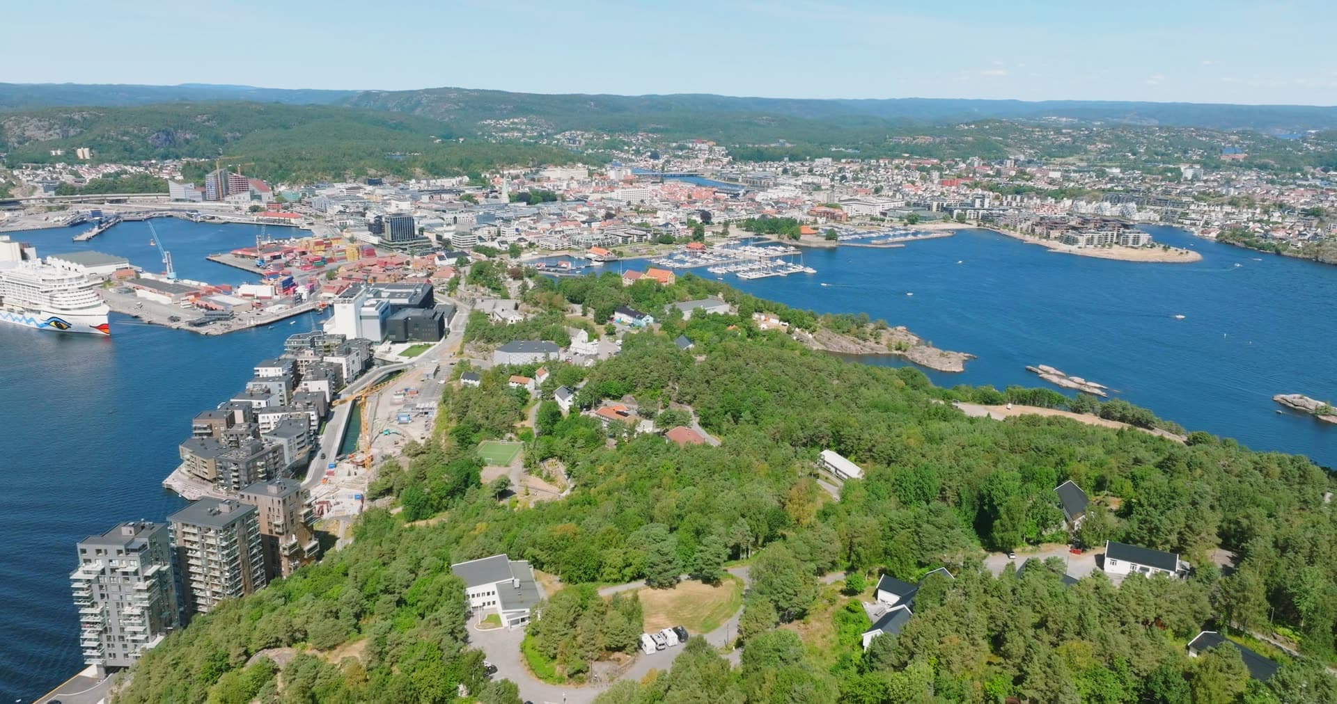 Forested headland with scattered homes overlooking dual harbors, Kristiansand, Norway