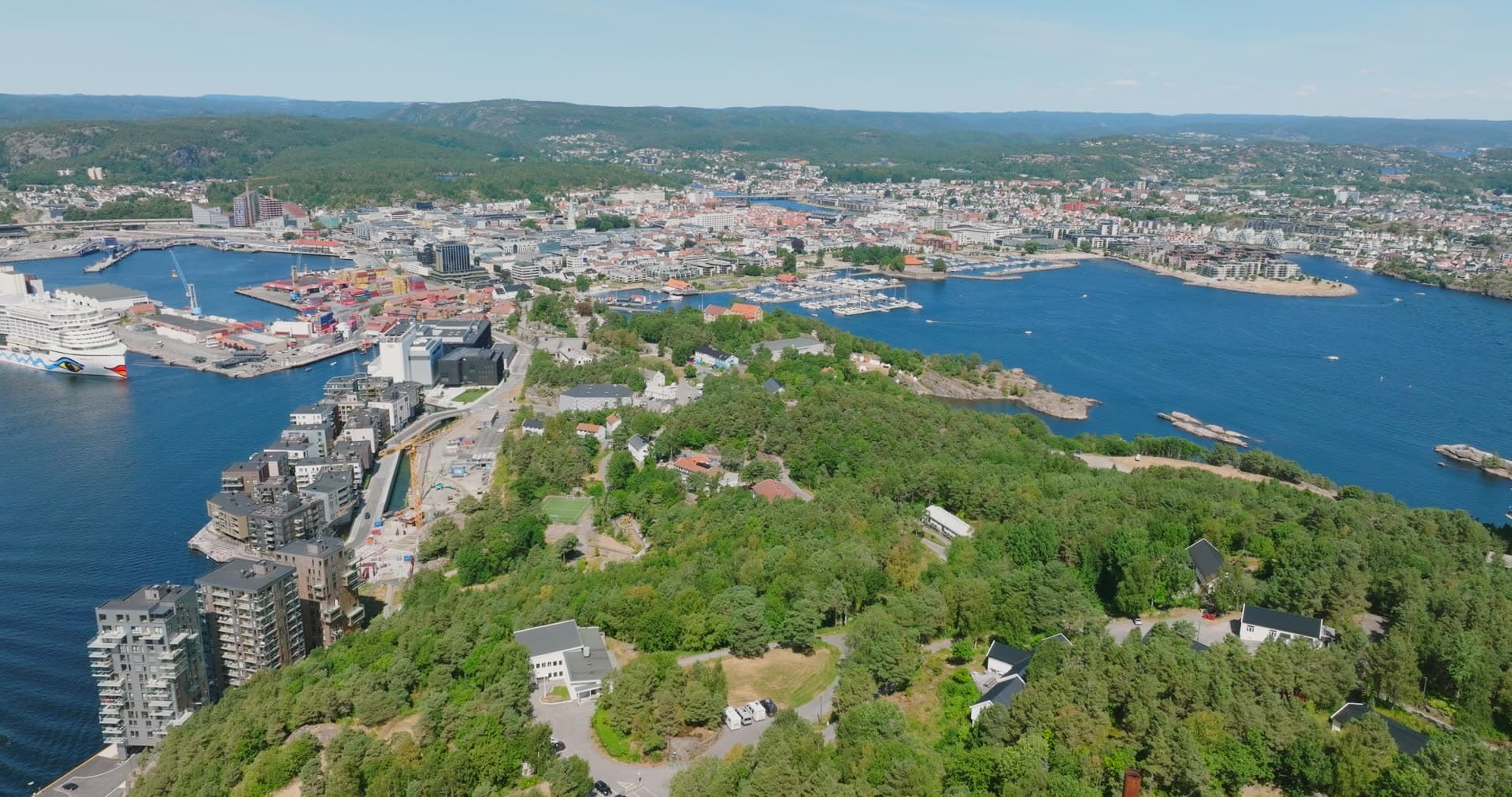 Densely forested headland with scattered waterfront houses, Kristiansand, Norway