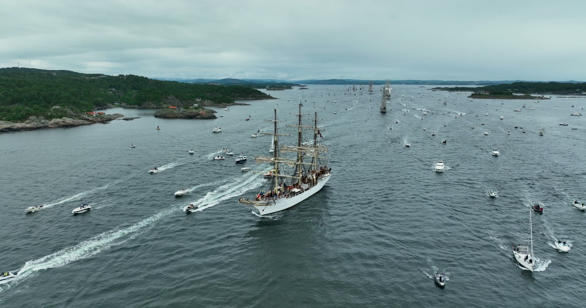 Traditional sailing vessel leading ceremonial boat procession, Kristiansand, Norway