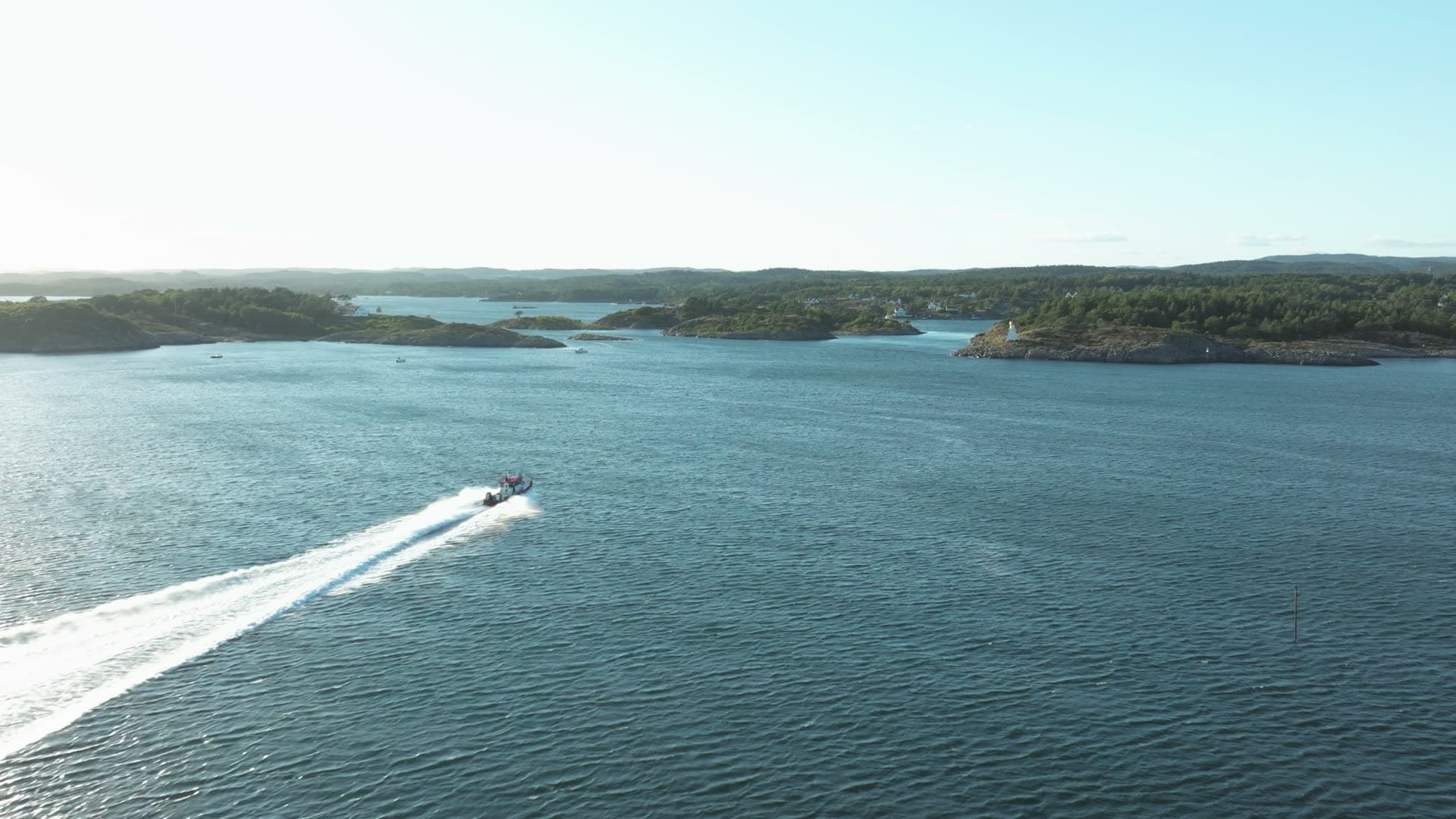 Speedboat trailing white wake across open water, Lillesand, Norway