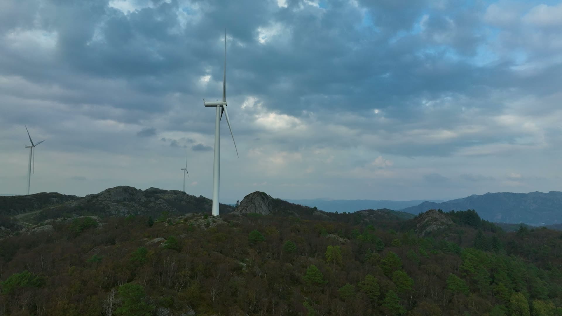 Turbine tower rising through forested rocky terrain, Lista, Norway