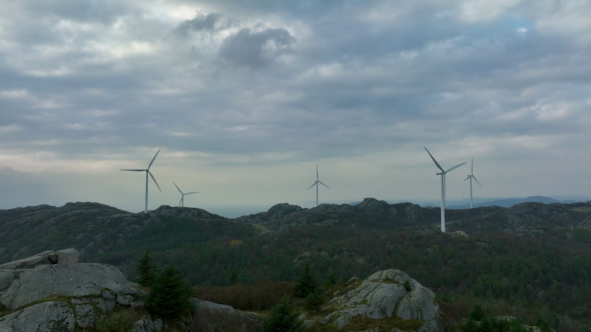 Multiple wind turbines across forested rocky landscape, Lista, Norway