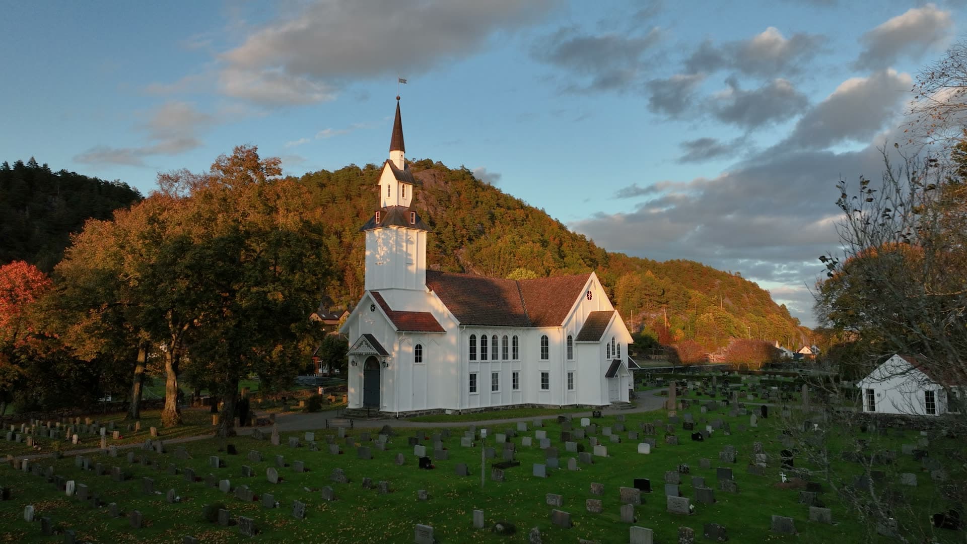 White chapel nestled in forested valley at dusk, Søgne, Kristiansand, Norway