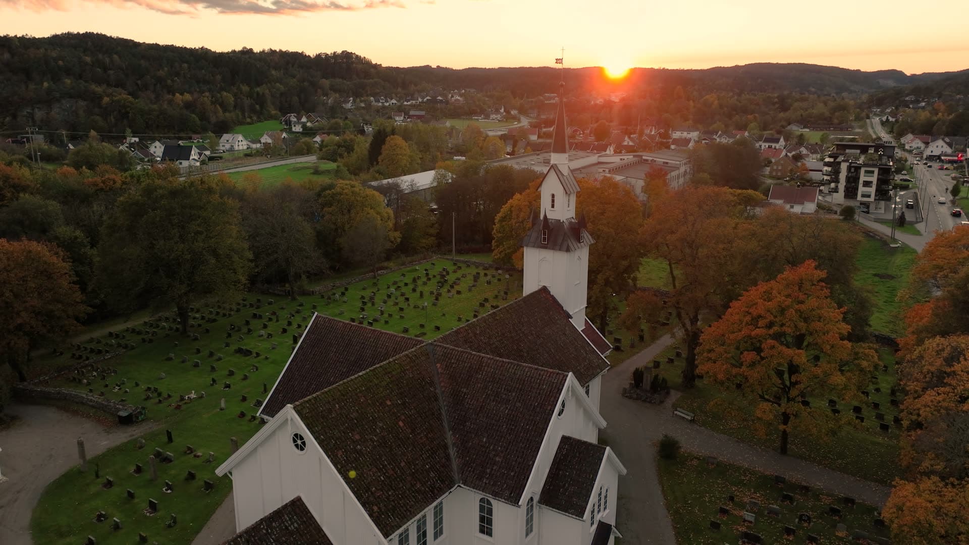Church steeple rising above autumn woodland valley, Søgne, Kristiansand, Norway
