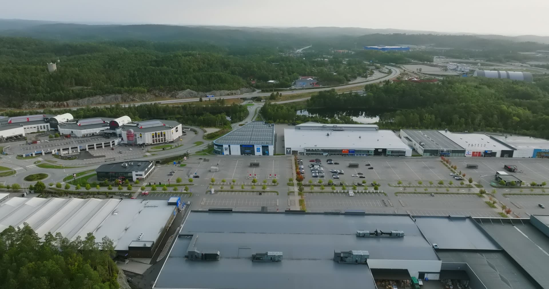 Highway interchange curving through forested commercial district, Sørlandsparken, Kristiansand, Norway