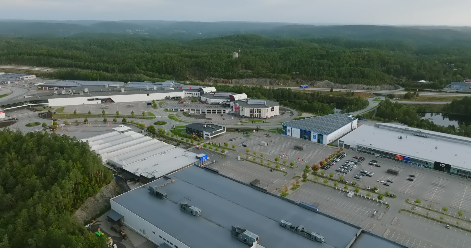 Sprawling retail district with forest canopy backdrop, Sørlandsparken, Kristiansand, Norway