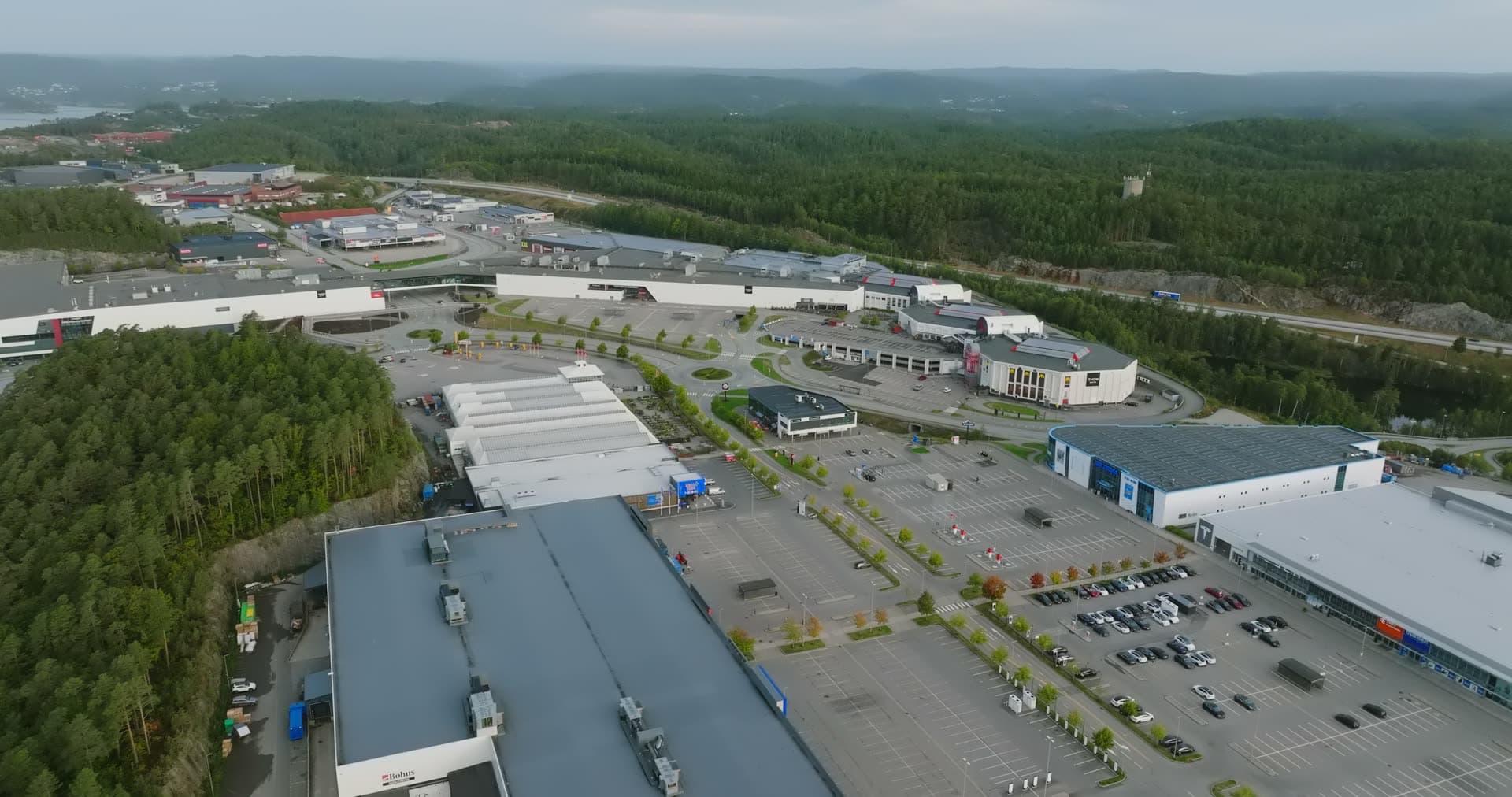 Commercial complex sprawl surrounded by dense forest, Sørlandsparken, Kristiansand, Norway